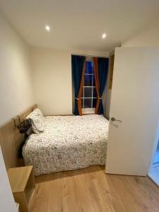 a bedroom with a bed and a window at Little Wooden Hut in London