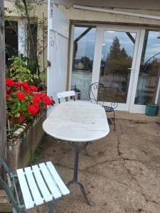 a white table and two chairs in front of a building at Ferme aux Arbres, B&B Appartement rez-de-chaussée 