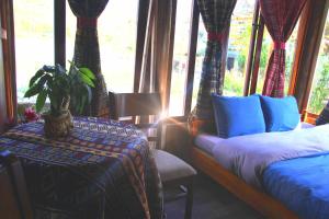 a bedroom with two beds and a potted plant in the window at Traditional Wooden house & trekking adventure in Sa Pa