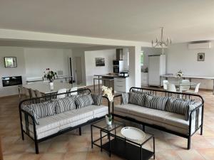 uma sala de estar com dois sofás e uma cozinha em Les Cerisiers Binel à Ronsac em Aigrefeuille
