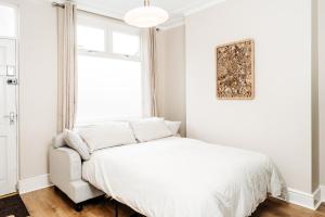 a white bedroom with a bed and a window at Alice's Central Stay: Parking + Close to the Motor Point Arena in Nottingham