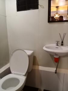 La salle de bains est pourvue de toilettes et d'un lavabo. dans l'établissement Z&J Transient Pad, à Butuan