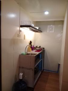 a small kitchen with a sink and a stove at Z&J Transient Pad in Butuan