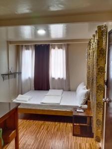 uma pequena cama num quarto com uma janela em Z&J Transient Pad em Butuan