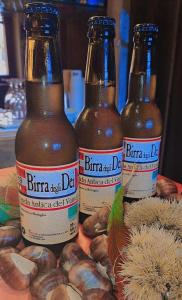 tre bottiglie di birra sedute su un tavolo con noci di Albergo Musolesi a Madonna di Fornelli