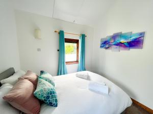 a bedroom with a white bed and a window at Seascape Bliss - Coastal Retreat in Youghal`s heart - Family Friendly - Long Term Price Cuts in Youghal
