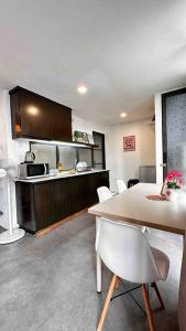 uma cozinha com uma mesa e cadeiras brancas num quarto em Free Parking, 6pax Family Duplex Empire Damansara em Petaling Jaya