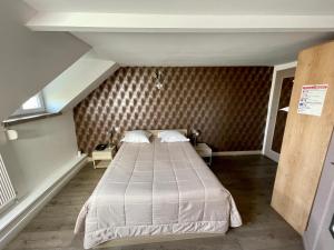 a bedroom with a large bed in a room at Hotel Restaurant Les Arcades in Valenciennes