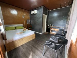 a small bedroom with a bed and two chairs at Suan Nai Kokut Resort in Ko Kood