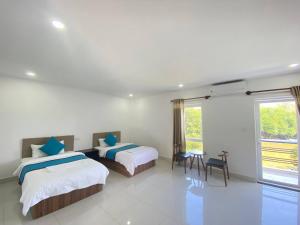 a bedroom with two beds and a table and chairs at O Mary River Resort in Sihanoukville