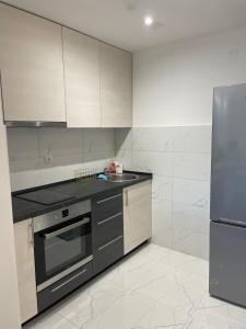 a kitchen with a sink and a stainless steel refrigerator at Stan na dan Bratunac in Bratunac