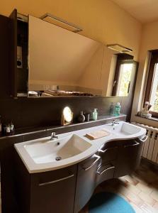 La salle de bains est pourvue d'un lavabo et d'un grand miroir. dans l'établissement Ferienhaus mit Pool zum Träumen und Entspannen für alle Sinne, à Bad Schmiedeberg