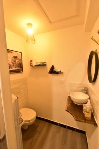 a bathroom with a white toilet and a sink at Appartement jacuzzi Gold&Night in Verneuil d'Avre et d'Iton