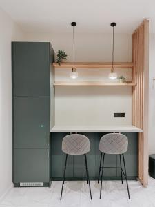a kitchen with two stools and a counter with shelves at Paulay 11 Center Designer Apartment in Budapest