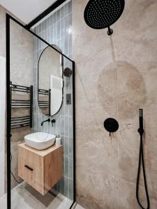 a bathroom with a sink and a shower with a mirror at Paulay 11 Center Designer Apartment in Budapest