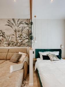 a bedroom with a bed and a couch and a painting at Paulay 11 Center Cosy Apartment in Budapest