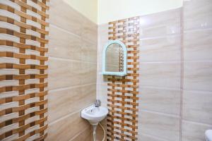 een badkamer met een wastafel en een spiegel bij FabExpress Kanha Dham in Kānpur