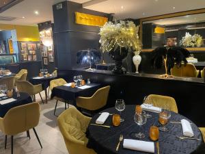 a restaurant with blue tables and yellow chairs at Hotel Restaurant Les Arcades in Valenciennes +3 photos