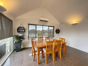 a dining room with a wooden table and chairs at Great Ocean Views Torquay in Torquay