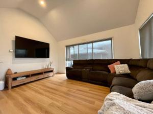 a living room with a couch and a flat screen tv at Great Ocean Views Torquay in Torquay