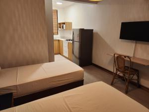 Habitación pequeña con 2 camas y cocina en La Perla Holiday Apartments en Pereybere