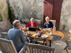 a group of people sitting around a wooden table at Au Pied du Chateau in Brantome en Perigord
