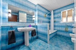 baño de azulejos azules con lavabo y bañera en Casa ideal para familias en Amposta, en Amposta