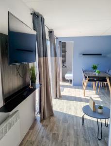 a living room with a television and a table at The Originals City, Ax Hotel, La Châtaigneraie in La Châtaigneraie