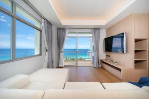 a living room with a white couch and large windows at Chic Design & Full Seaview 2BR Karon Condo 16C, near Beach in Karon Beach