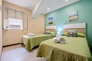 2 camas en una habitación con paredes verdes en Casa ideal para familias en Amposta, en Amposta