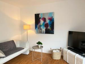 a living room with a white couch and a tv at Neue, ruhige Ferienwohnung in Wolfegg
