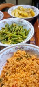 a table topped with plates of food with broccoli at Hilltop Guest House in Ella