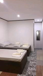 three beds in a room with a wall at green aa garden resort in Sikatuna