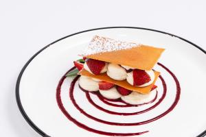 une assiette avec un dessert avec des fraises sur elle dans l'établissement Le Manoir De La Poterie & Spa, à Cricquebœuf