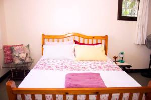 1 dormitorio con 1 cama grande con marco de madera en Charming 2 bedroom house, en Entebbe