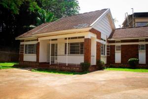 una pequeña casa con un ladrillo en Charming 2 bedroom house en Entebbe