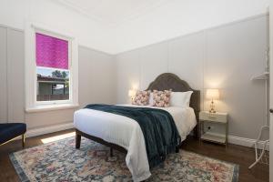 - une chambre blanche avec un lit et une fenêtre dans l'établissement ‘Endsleigh Cottage’ - Modern Luxury, Aged Charm, à Cessnock