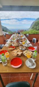 uma mesa de madeira com comida e bebidas em Hilltop Guest House em Ella