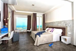 Baldinini Hotel في ريميني: غرفه فندقيه بسرير ومكتب ونافذه