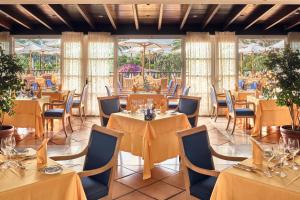 een eetkamer met tafels, stoelen en ramen bij Seaside Grand Hotel Residencia - Gran Lujo in Maspalomas