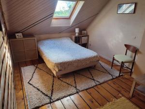 a bedroom with a bed and a chair in a attic at Pascanono - Location de maison de vacances avec jardin pour séjour à Le Palais, Belle-Ile-en-mer in Le Palais