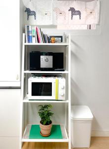 a white shelf with a microwave and a plant on it at BlueMoon 2Bedroom 1Toilet in Seoul