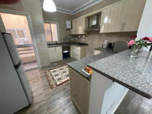a kitchen with a refrigerator and a counter top at Elegant Garden-view 1BR in New Cairo in Cairo