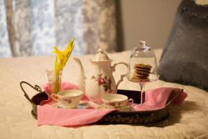 a tray with cups and a tea set on a bed at Bees B & B in Mount Airy