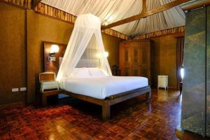 ein Schlafzimmer mit einem Bett mit Moskitonetz in der Unterkunft The Journey Resort Pattaya in Na Jomtien