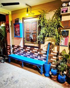 a blue bench in front of a building with plants at Dream Vision Guest House in Diu