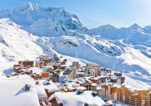 a city covered in snow with mountains in the background at Résidence & Spa Le Machu Pichu in Val Thorens