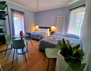 um quarto com 2 camas, uma mesa e cadeiras em Residenza Gramsci em Matera