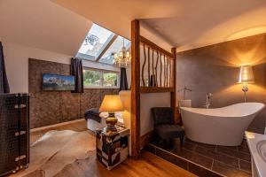ein Badezimmer mit einer großen Badewanne und ein Schlafzimmer in der Unterkunft Das Bucher in Ehrwald