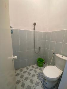 a bathroom with a toilet and a green bucket at Walasa Homes Werdyningsih 